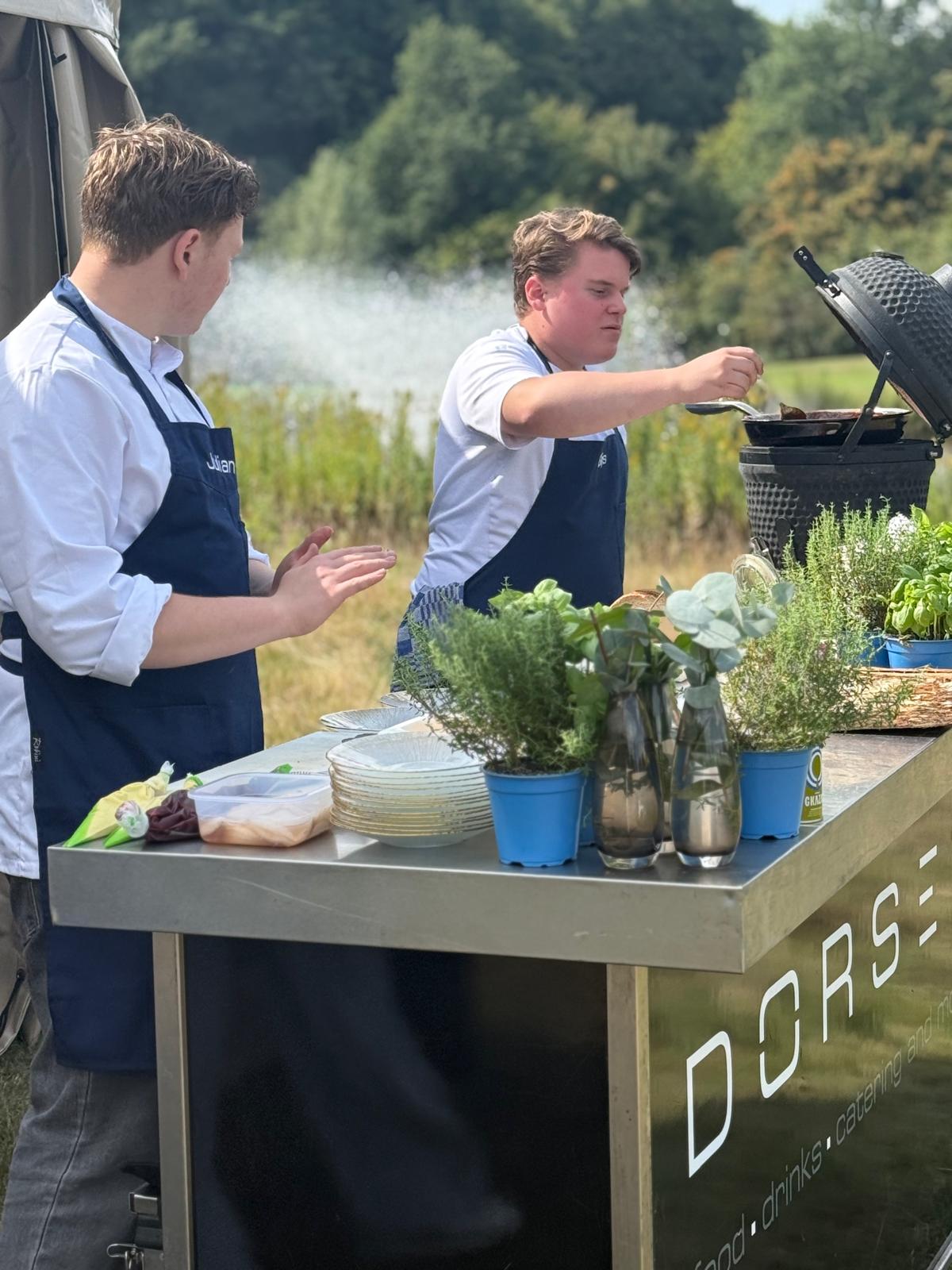 Jonge chefs bereiden gerechten bij de vijver