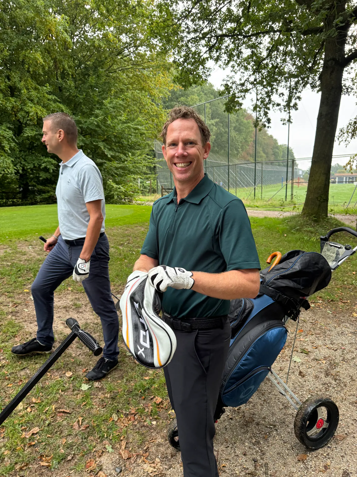 Twee deelnemers lachend bij de driving range