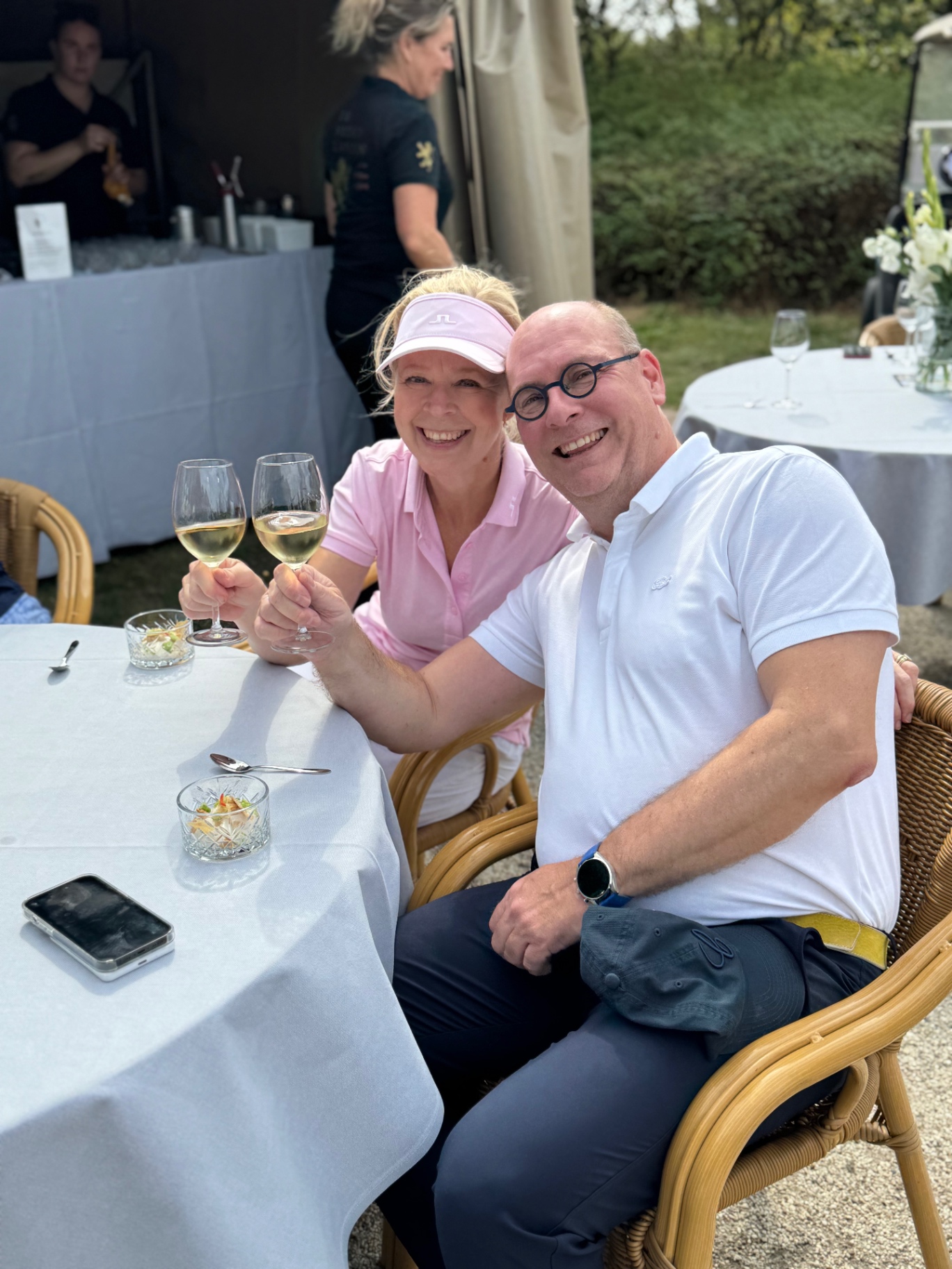 Deelnemers proosten met een glas witte wijn