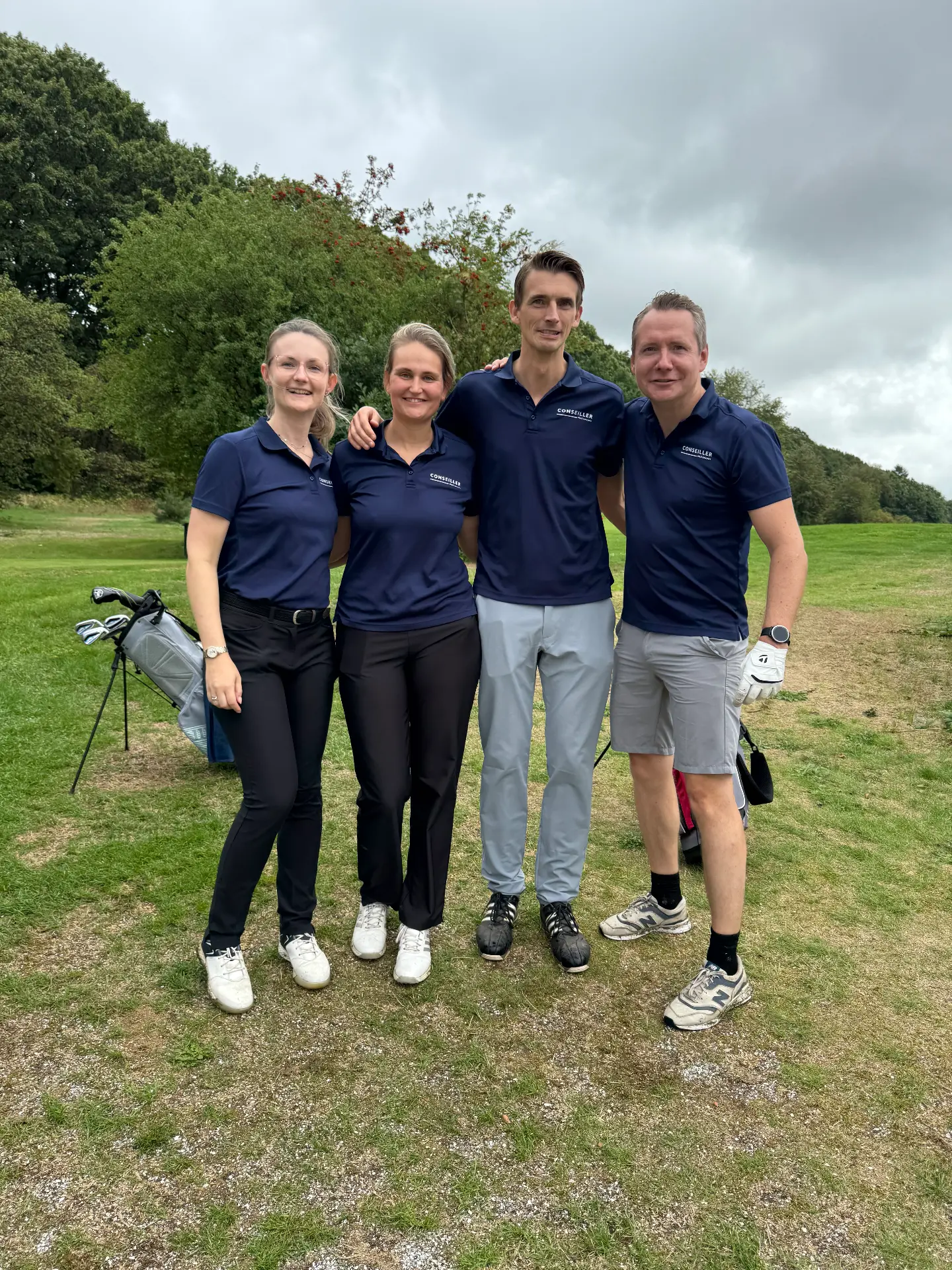 Team Conseiller in donkerblauwe poloshirts op de baan