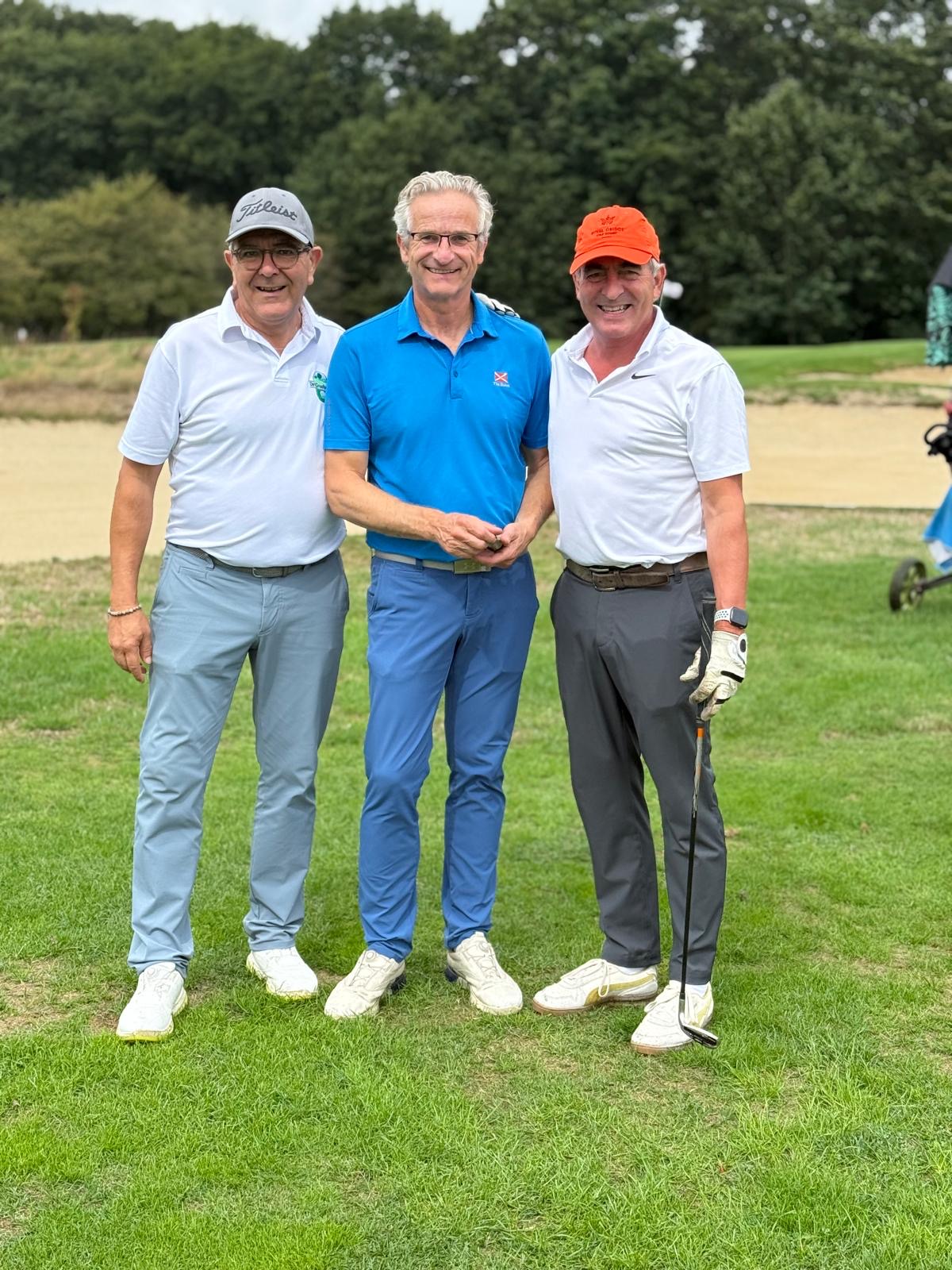 Drie deelnemers poseren op de fairway